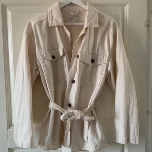 Beige jacka med knytbälte - Snygg beige jacka med knytbälte. Perfekt nu till våren🥰