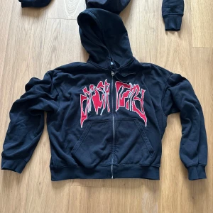 Svart hoodie med röd och vit tryck - Svart hoodie från weekday, lite cropped fit strlk M.