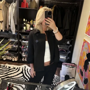 Svart kappa med knappar - Snygg svart kappa med stora knappar och trekvartsärm. Perfekt för höst och vår. Klassisk design som passar till många olika outfits.säljer endast vid bra bud🩷