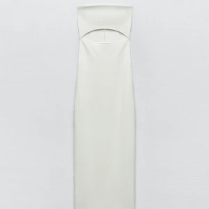 Vit axelbandslös långklänning - Elegant vit axelbandslös långklänning med en stilren och minimalistisk design. Perfekt för formella tillfällen med sin släta yta och klassiska snitt.