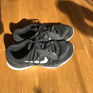 Svarta Nike Flex TR 6 träningsskor - Säljer ett par svarta Nike Flex TR 6 träningsskor med vit sula och snörning. Passar för träning med sin flexibla design och bekväma passform. Har bara använt dem inomhus ett fåtal gånger. 
