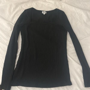 Svart ribbad tröja från Bubbleroom - Säljer en stilren svart ribbad tröja från Bubbleroom. Tröjan har långa ärmar och en klassisk passform som passar perfekt till både vardag och fest. 