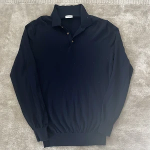 Mörkblå pikétröja från John Henric - Säljer en skitsnygg mörkblå pikétröja från John Henric. Tröjan har långa ärmar och en klassisk krage med knappar. Perfekt för en avslappnad men ändå uppklädd look. Tröjan är i nyskick och har inga defekter.