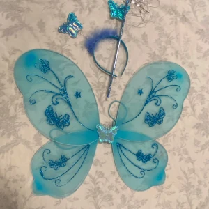  fjärilsvingar med trollstav och diadem  - Snyggt rött diadem med matchande fjärilsvingar och trollstav. Perfekt för en magisk utklädnad med glittriga detaljer och fjädrar. 69kr/paket /3delar, skicka med postnord , helt ny 