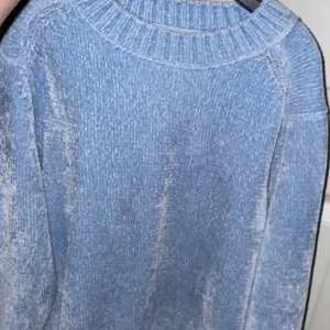 Ljusblå stickad tröja från 157 - Mysig ljusblå stickad tröja från 157. Perfekt för kyliga dagar med sin mjuka och bekväma passform. Tröjan har en ribbad krage och långa ärmar som håller dig varm och stilren. Frakt tillkommer.