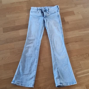 Ljusblå bootcut jeans från H&M - Säljer ett par ljusblå bootcut jeans från H&M med justerbar midja och låg midja. Perfekta för en avslappnad stil med en klassisk bootcut passform.