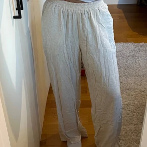 Beige linnebyxor - Säljer ett par bekväma beige linnebyxor med elastisk midja från Shein. Byxorna har en avslappnad passform och är perfekta för varma dagar. De är tillverkade i ett lätt och luftigt material som ger en skön känsla.
