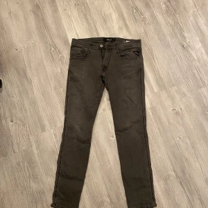 Grå jeans från Replay - Snygga grå jeans från Replay. De har en dragkedja och knapp framtill samt Replay-loggan baktill. Storlek 31 - 32