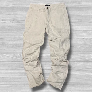 Beige byxor från LC Waikiki - Snygga beige byxor från LC Waikiki i en klassisk stil. De har en knapp och dragkedja framtill samt hällor för bälte. Perfekta för en avslappnad look.