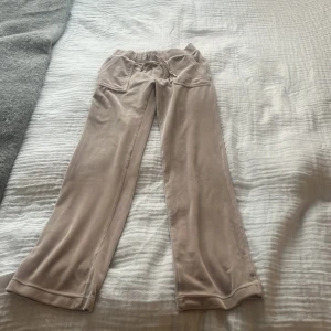 Beige mjukisbyxor med snörning - Säljer ett par bekväma beige mjukisbyxor med snörning i midjan och fickor med knappar både fram och bak. Obs en av metallbitarna på snöret e borta