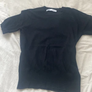 Svart t-shirt aktig tröja med tjockt material från Zara - Säljer en klassisk svart t-shirt från Zara i storlek S. Den har en enkel design med korta ärmar och rund hals. Perfekt basplagg för alla tillfällen. 🖤