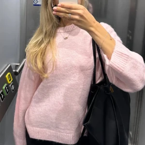 Rosa stickad tröja - Säljer en mysig rosa stickad tröja med långa ärmar. Perfekt för kyliga dagar och ger en mjuk och bekväm känsla. Passar bra till både jeans och kjol. Enkelt att matcha med andra plagg i garderoben. Tröjan är aldrig använd, bara testad en gång!
