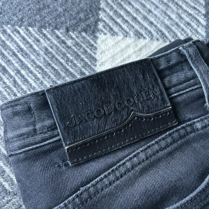 Svarta jeans från Jacob Cohen - Snygga svarta jeans från Jacob Cohen med knappgylf och klassisk femficksdesign. Tillverkade i Italien med högkvalitativt material för en stilren look. Perfekta för dig som vill ha en tidlös stil.