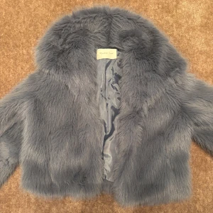 Grå pälsjacka - Säljer en lyxig och fluffig grå/blå fuskpäls🩷 köp i en liten butik i usa därav vet jag inte riktigt märket! använd en gång! storlek M men passar även S