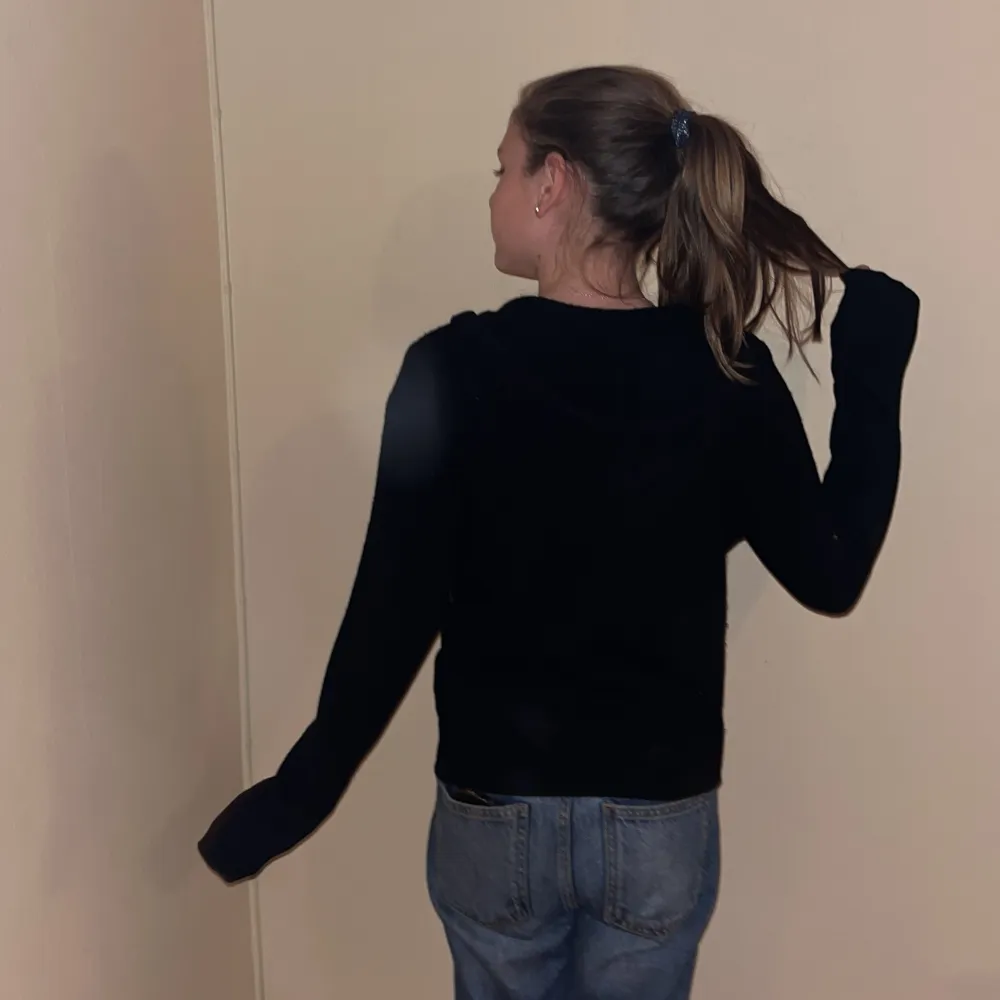 Säljer en svart hoodie med dragkedja framtill. Den har en normal passform och långa ärmar. Perfekt för en avslappnad stil. 🖤. Neuletakit & Villapaidat.