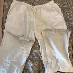 Vita linnebyxor  - Ett par vita linnebyxor från Gina tricot. Trasiga längst ner vid benen. Säljer pga att de är för långa. Perfekt till sommaren 