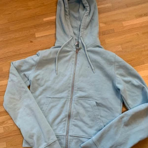 Ljusblå hoodie från H&M - Säljer en ljusblå hoodie från H&M Divided. Den har en dragkedja framtill och en praktisk huva med dragsko. Perfekt för våren. 🩵