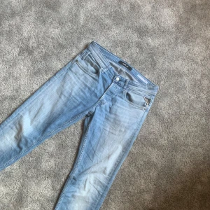 Blå jeans från Replay - Snygga ljusblå jeans från Replay med straight fit. Klassisk femficksdesign och knappgylf. Perfekta för en avslappnad stil.