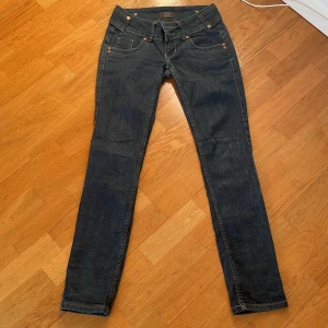 Blå jeans från Gina  - Snygga blå lågmidjade jeans från Gina med en klassisk femficksdesign och dekorativa sömmar på bakfickorna. Perfekta för en avslappnad look. Säljer då de är för små 