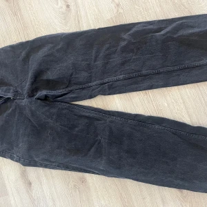 Svarta jeansbyxor - Snygga svarta jeansbyxor med en klassisk design. De har en rak passform och är perfekta för en avslappnad stil. Byxorna har en dragkedja och knapp framtill.