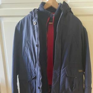 Blå parkajacka från Polo Ralph Lauren - Säljer en snygg blå parkajacka från Polo Ralph Lauren. Jackan har en huva och dragkedja framtill. Insidan är fodrad med mjuk fleece för extra värme. Fleece västen går även att ta av och endast använda den som väst eller om man bara vill använda jackan. Den är till för att kunna ha året runt och är perfekt för både varma och kyligare dagar!👌👌