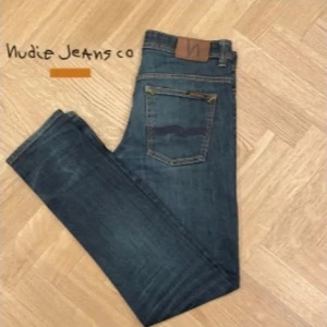 Blå Nudie Jeans - Snygga blå jeans från Nudie Jeans med klassisk femficksdesign. De har en knappgylf och en läderpatch med logotyp baktill. Perfekta för en stilren look. Jag på bilden brukar ha w29 l32/34. Skriv privat för exakta mått fler bilder eller funderingar