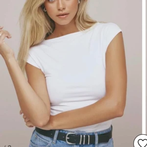 Vit kortärmad topp  - Säljer en stilren vit topp.Den har en tight passform och korta ärmar, perfekt för en minimalistisk look. Toppen är gjord i ett mjukt och stretchigt material som sitter skönt mot kroppen.