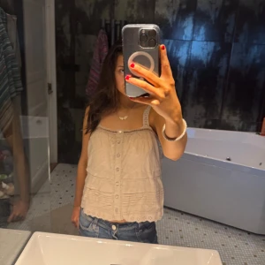 Beige ärmlös blus -  En söt beige blus med knappar framtill och spetsdetaljer på axelbanden. Perfekt för varma dagar och kan enkelt matchas med jeans eller kjol. Aldrig använd men ingen prislapp kvar på!💕