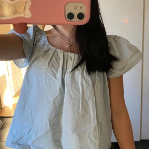 Ljusblå topp - Säljer en söt ljusblå topp med korta ärmar. Toppen har en luftig passform och är perfekt för varma dagar. Den har en elastisk kant vid axlarna för en bekväm passform och så kan man ha på sig den vanligt eller offshoulder. Pris kan diskuteras 💕💕