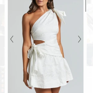 vit klänning  - Snygg vit oneshoulder klänning med en stor rosett på axeln och en knytning i midjan. Perfekt studentklänning!  enbart provad 