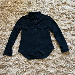 Svart långärmad skjorta i mockaimitation - Svart långärmad skjorta i mockaimitation. I fint skick