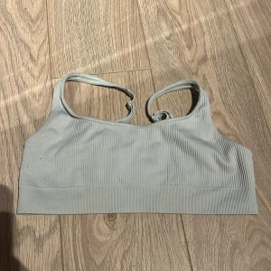 Grå ribbad linnetopp - Säljer en stilren grå ribbad linnetopp med smala axelband. Perfekt för en avslappnad look eller som basplagg i garderoben.