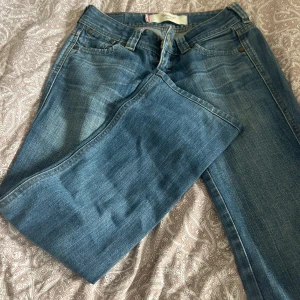 Blå bootcut jeans från Levi's - Snygga blå bootcut jeans från Levi's med klassisk femficksdesign och knappgylf. Perfekta för en avslappnad stil. Märketikett på baksidan och röd Levi's-flik på bakfickan. Priset går att diskutera!💓