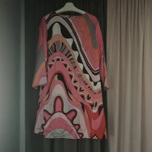 Färgglad klänning från Glamorous - Säljer en färgglad klänning från Glamorous med ett abstrakt mönster i rosa, orange och svart. Klänningen har trekvartsärmar och en lös passform. Perfekt för att sticka ut med stil! 🌈