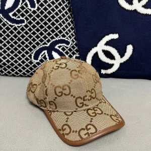Beige keps från Gucci - Snygg beige keps från Gucci med det klassiska GG-mönstret i brunt. Kepsen har en brun kant runt skärmen och är tillverkad i ett slitstarkt material. Perfekt för att ge din outfit en lyxig touch.