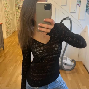 Svart spetsblus - Säljer en elegant svart spetsblus med långärmad design. Blusen har ett vackert mönster och en figurnära passform som ger en stilren look. Perfekt för att lägga till en touch av elegans till din outfit.