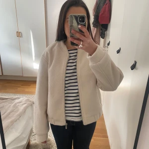Beige teddyjacka från New Yorker  - beige teddyjacka från Amisu med dragkedja framtill. Den är tillverkad i ett mjukt material som ger en skön känsla. Fin till våren! Hyfsat varm också! Aldrig använd. 