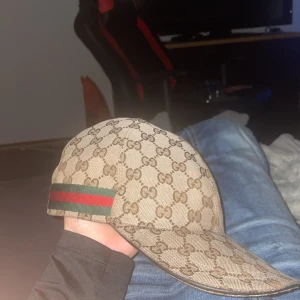 Gucci keps med GG-mönster - ÄKTA Gucci keps säljer den för söker byte mot en äkta rosa eller Blå eller köpa den för priset som står, den är är i mycket bra skick för att vara den gamla modellen 