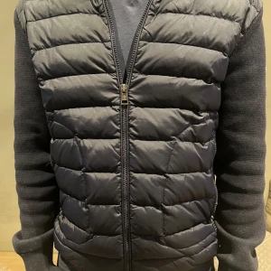 Mörkblå cardigan från Moncler - Snygg mörkblå cardigan från Moncler med quiltad framsida och dragkedja. Västen har Moncler-logga på ärmen. Den är köpt på CareofCarl för cirka 10.000kr kvitto osv finns i DM,skick 8,5/10.Pris är ej hugget i sten.                                                                Hör av dig vid minsta fundering!💪