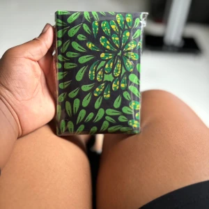 Anteckningsbok med grön blommig design - En snygg anteckningsbok med ett unikt, grönt blommönster på omslaget. Perfekt för att skriva ner tankar, idéer eller skolarbete. Liten och smidig att ta med överallt – gör dina anteckningar mer personliga och inspirerande! Följ oss för mer på Instagram; @shop_with_tyra