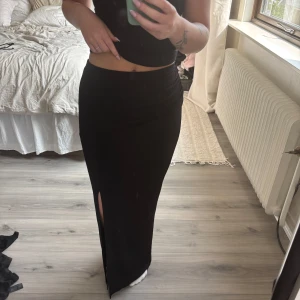 Svart långkjol med slits - Svart långkjol med slits från NA-KD. Strl XS, helt oanvänd lapp sitter kvar.