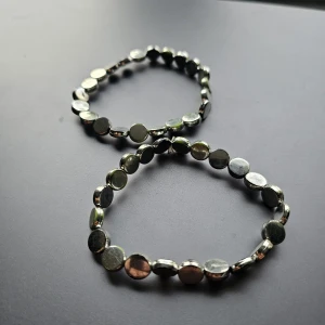 Två elastiska armband i metall - Två coola armband med runda, platta pärlor i silver - smått rost/kopparfläckar därav lägre pris