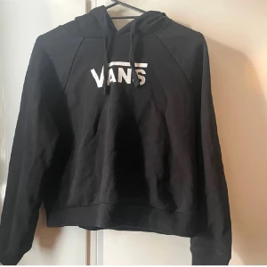 Svart hoodie från Vans med vit logga  - Svart hoodie från Vans i storlek XS med vit Vans-logga framtill. Klassisk modell med huva och snörning, ribbade muddar och lång ärm fint skick 