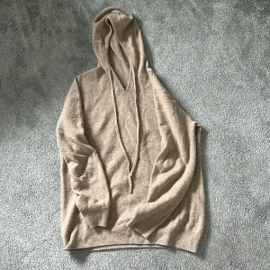 Cashmere hoodie - Stilren hoodie som passar perfekt vid de flesta tillfällen. Tröjan är i bra skick, den e lite nopprig och en metallsak på snörena är borta därav priset. 