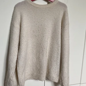 Beige stickad tröja från H&M - Mysig beige stickad tröja från H&M i storlek 134/140. Tröjan har rund halsringning. Tröjan har blivit lite nopprig.