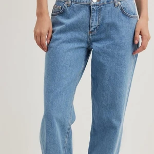 Ljusblåa wide jeans  - Säljer ett par ljusblåa jeans med breda ben och klassisk femficksdesign. Jeansen har låg midja och är tillverkade i bomull. Perfekta för en avslappnad och trendig look.
