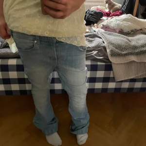 Ljusblå baggy jeans med cargofickor - Säljer ett par ljusblå jeans med baggy passform och cargofickor på sidorna. Jeansen har klassisk femficksdesign, raka ben och är tillverkade i denim. Perfekta för en avslappnad och trendig stil. Storlek 146