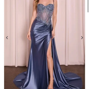 Blå långklänning med spets och slits - Supersnygg blå långklänning i satin med glittrig spets upptill och genomskinlig korset. Perfekt för bal :) endast använd en gång . Köpt på proms and weddings för 3500 kr (2950 på hemsidan + 500 kr för att sy) . Pris kan diskuteras