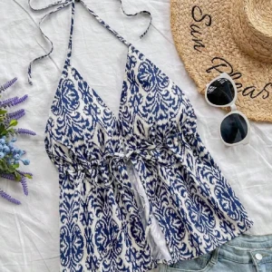 Blåvit halterneck linnetopp - Supersnygg blåvit linnetopp med knyt i nacken och under bysten. Toppen har ett unikt mönster och lätt v-ringning, perfekt för varma dagar. Luftigt material och avslappnad passform gör den både bekväm och trendig.