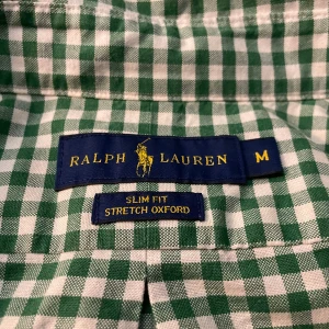 Rutig Ralph Lauren skjorta - Snygg grön och vit rutig skjorta från Ralph Lauren i storlek M. Perfekt för sommarn och för en avslappnad stil. Skjortan är i mycket bra skick och det finns inga synliga tecken på användning. Priset är INTE hugget i sten, så vid snabb affär kan jag tänka mig att sänka priset lite. 